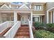 Inviting covered front porch with brick steps and white railing at 6 Alston Ne Pl, Atlanta, GA 30324