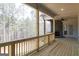 Covered porch with wood floors and railings, featuring a stone fireplace that provides a cozy atmosphere at 5480 Two Hills Dr # 31, Fairburn, GA 30213
