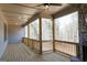 Covered back porch with wood floors, wooden railings, and a stone fireplace, perfect for outdoor living at 5480 Two Hills Dr # 31, Fairburn, GA 30213