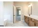 Spacious bathroom with double sinks, modern fixtures, view to primary bedroom, tub and tile flooring at 5480 Two Hills Dr # 31, Fairburn, GA 30213