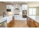 Kitchen features an island with marble countertops, stainless appliances, wood floors and a white farmhouse sink at 5480 Two Hills Dr # 31, Fairburn, GA 30213