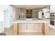 This kitchen has a large island with marble countertops, stainless appliances, wood floors and white cabinets at 5480 Two Hills Dr # 31, Fairburn, GA 30213