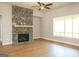 Cozy living room featuring a stone fireplace, hardwood floors, and a ceiling fan at 5480 Two Hills Dr # 31, Fairburn, GA 30213