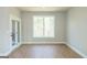 A modern room with light wood flooring and a large window letting in natural light and neutral-colored walls at 5480 Two Hills Dr # 31, Fairburn, GA 30213