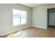This empty room features light wood floors, neutral colored walls, a big window, and white trim at 5480 Two Hills Dr # 31, Fairburn, GA 30213