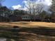 View of backyard of house and wooden gazebo surrounded by brown lawn on a sunny day with blue skies at 55 Gill Ln, Stockbridge, GA 30281