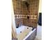 Bathroom with white tub and brown and white tiled shower with decorative border at 55 Gill Ln, Stockbridge, GA 30281