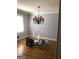 Dining room with hardwood floors, gray walls, and decorative light fixture with buckets of paint on the floor at 55 Gill Ln, Stockbridge, GA 30281