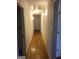Hallway with hardwood floors, white walls, and lighting fixtures at 55 Gill Ln, Stockbridge, GA 30281