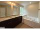 Bright bathroom featuring double vanities, granite counters, a soaking tub, and a natural light window at 1555 South Bethany Rd, Locust Grove, GA 30248