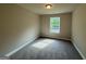 Bedroom featuring a sunny window, neutral carpeting, and fresh paint at 1555 South Bethany Rd, Locust Grove, GA 30248