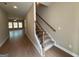 Hallway with wood floors leading to living room and stairs with wood and decorative iron at 1555 South Bethany Rd, Locust Grove, GA 30248