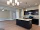 Open kitchen with island, granite countertops, dark cabinetry, and stainless steel appliances at 1555 South Bethany Rd, Locust Grove, GA 30248