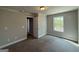 Neutral bedroom features carpet, a window with natural light, and a white door at 1547 South Bethany Rd, Locust Grove, GA 30248