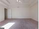 Spacious bedroom featuring neutral carpet, ceiling fan, and a tray ceiling at 334 Royal Crescent Way, Stockbridge, GA 30281