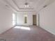Bright bedroom featuring neutral carpet, ceiling fan and tray ceiling at 334 Royal Crescent Way, Stockbridge, GA 30281