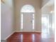 Inviting foyer with a white front door with glass accents, shiny wooden floor and neutral color walls at 334 Royal Crescent Way, Stockbridge, GA 30281