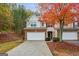 Two-story townhome with brick and siding exterior, two-car garage, and autumn landscaping at 512 Hillside Trl, Woodstock, GA 30188