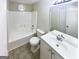 Well-lit bathroom features a tub with shower, white vanity, and decorative stained-glass window at 4405 Cary Dr, Snellville, GA 30039