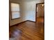 Bedroom featuring hardwood floors, a window, and an open door to another room, creating a light-filled space at 1511 Walker Ave, College Park, GA 30337