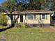 Charming one-story home featuring large windows, a well-maintained lawn and mature landscaping at 1511 Walker Ave, College Park, GA 30337
