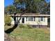 Modest single story home showing large front yard with mature trees and the need for some care at 1511 Walker Ave, College Park, GA 30337