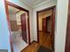 Hallway with hardwood floors leading to a bathroom with black and white tile and a bedroom closet at 1511 Walker Ave, College Park, GA 30337
