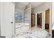 Modern bathroom with a marble tile floor, garden tub, walk-in shower, and natural light at 1406 Stone Ridge Ct, Hampton, GA 30228