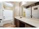 A bathroom featuring a modern vanity with a wide mirror and contrasting wood-look flooring at 1406 Stone Ridge Ct, Hampton, GA 30228