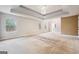 A large main bedroom featuring tray ceilings, lots of natural light, and neutral carpeting at 1406 Stone Ridge Ct, Hampton, GA 30228