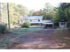 Exterior view of a two story home, shed and carport situated on a spacious lot and driveway at 1372 Auburn Rd, Dacula, GA 30019