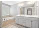 Bright bathroom featuring a double vanity, a large mirror, and a separate bathtub at 1714 Boulder Walk Se Ln, Atlanta, GA 30316