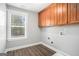 Bright laundry room featuring wooden cabinets, a window, and laminate flooring at 1714 Boulder Walk Se Ln, Atlanta, GA 30316