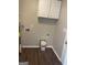 Functional laundry room with upper cabinets and laminate flooring at 11684 Heritage Dr, Hampton, GA 30228