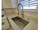 Close up shot of stainless steel sink with modern faucet, white cabinets and countertops, and natural light at 4284 Caroline Ct, Douglasville, GA 30135