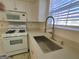 Close up on updated white kitchen with stainless steel sink, modern faucet, and bright natural light at 4284 Caroline Ct, Douglasville, GA 30135