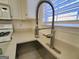 Close up of stainless steel kitchen sink featuring modern faucet, with natural light shining through window at 4284 Caroline Ct, Douglasville, GA 30135