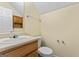 Cozy bathroom featuring wood vanity, sink, toilet, and overhead storage at 167 London Dr, Mcdonough, GA 30253