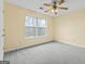 Bright bedroom with plush carpet, ceiling fan, and window view at 167 London Dr, Mcdonough, GA 30253