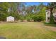 Expansive backyard featuring lush green grass, mature trees, and a storage shed at 85 Bloomfield Way, Sharpsburg, GA 30277