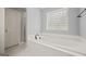 A well-lit bathroom features a soaking tub, large window, and gray walls at 85 Bloomfield Way, Sharpsburg, GA 30277