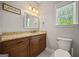 Bathroom featuring a marble vanity, window, decorative mirror, and neutral walls and floors at 85 Bloomfield Way, Sharpsburg, GA 30277