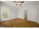 Spacious bedroom with gleaming hardwood floors, a window with natural light, and two closet doors at 85 Bloomfield Way, Sharpsburg, GA 30277