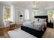 Bright main bedroom features a queen bed, tall windows, tray ceiling, a ceiling fan and hardwood floors at 85 Bloomfield Way, Sharpsburg, GA 30277