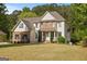 Charming two-story home boasts a manicured lawn and inviting brick and vinyl facade, creating a welcoming curb appeal at 85 Bloomfield Way, Sharpsburg, GA 30277