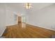 Open-concept living area featuring hardwood floors, neutral walls, and access to dining and bedroom at 85 Bloomfield Way, Sharpsburg, GA 30277