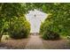 Charming storage shed framed by lush greenery, accessible via a brick pathway at 85 Bloomfield Way, Sharpsburg, GA 30277