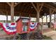 Community free library decorated with patriotic bunting and surrounded by colorful flowers at 708 Ocmulgee Xing, Locust Grove, GA 30248