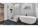 Modern bathroom featuring glass enclosed shower, soaking tub and black marble floors at 426 Ayers Rd, Bowdon, GA 30108