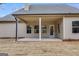 View of the covered patio featuring neutral-toned walls, square windows and a concrete surface overlooking the yard at 426 Ayers Rd, Bowdon, GA 30108